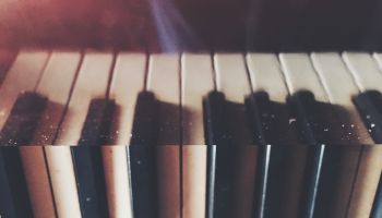 Close-Up Of Piano Keys Reflecting On Metal