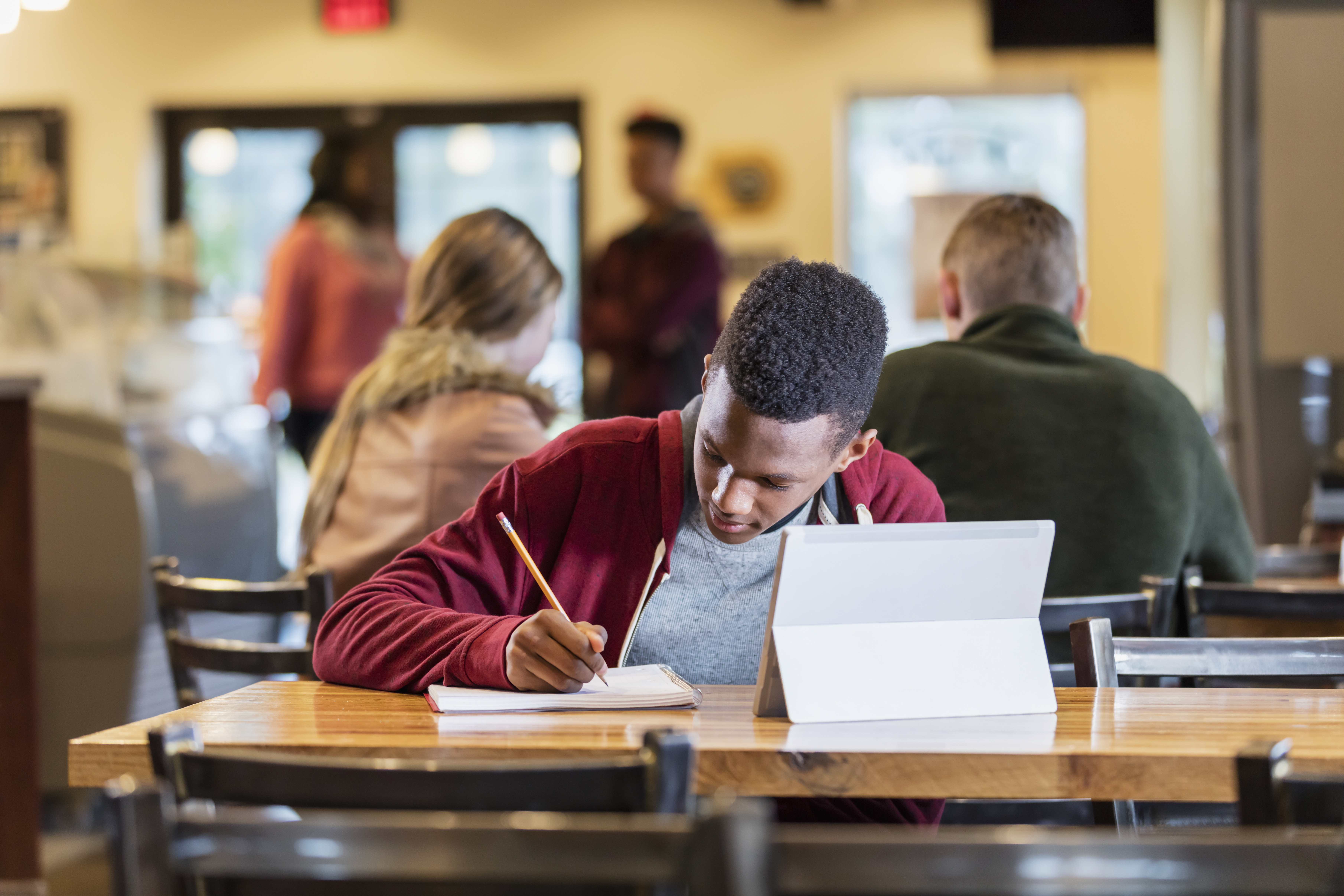 African-American teenage boy studying in a restaurant
