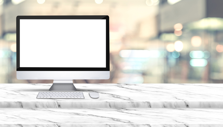 Close-Up Of Computer With Blank Monitor On Table