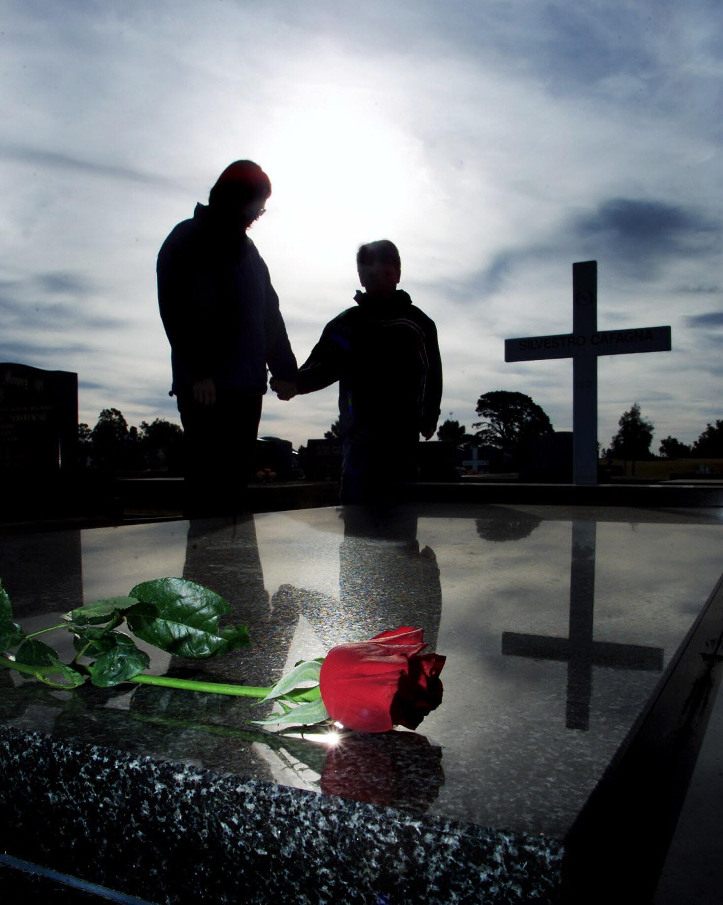 Red rose lying on a grave at a cemetery, 22 July 2002. NCH Picture by DARREN PA