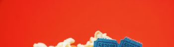 Popcorn And Movie Tickets With Numbers In Container Against Red Background
