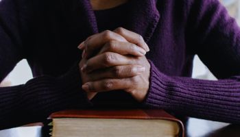 Woman Prays Before Reading Bible at Home