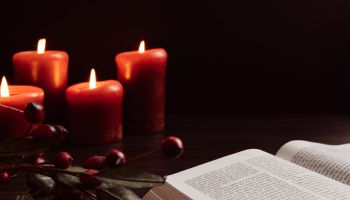 Open bible and lit red candles